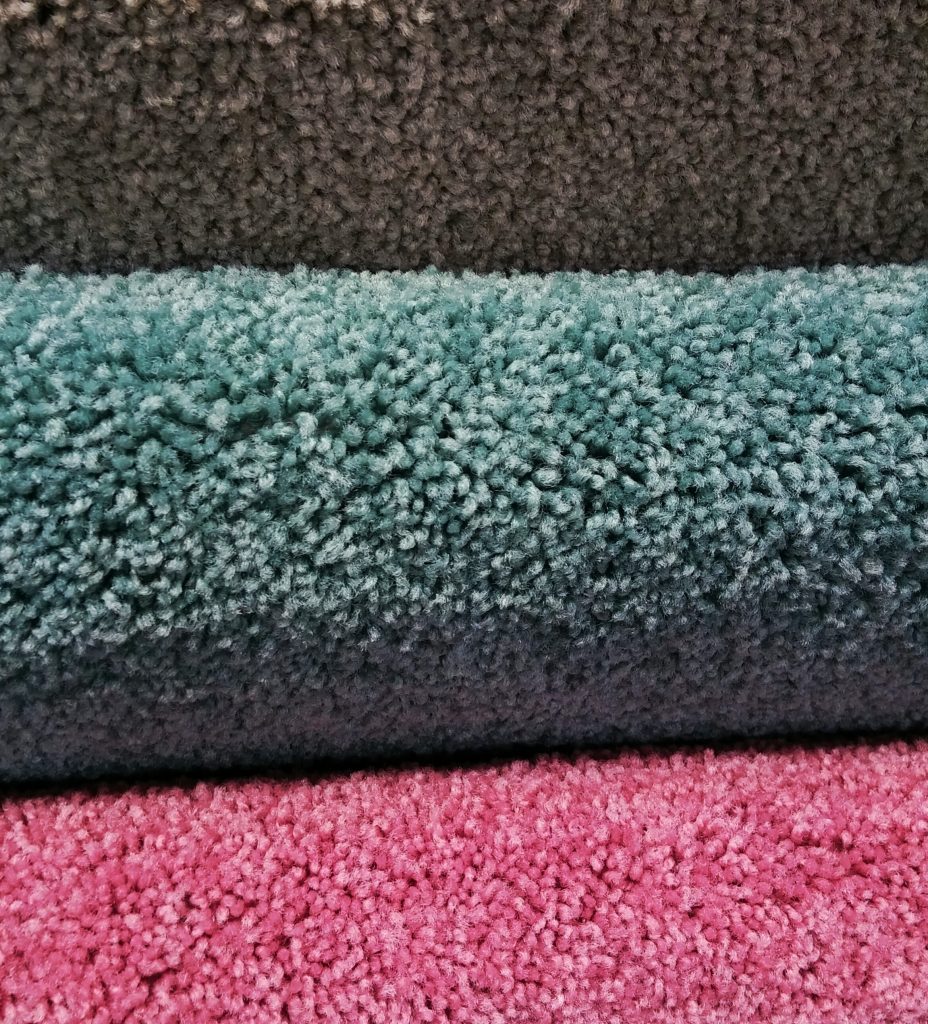 Thick carpet samples in brown, teal and pink